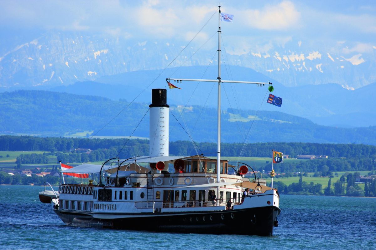 Boat on Lake Constance with the Alps behind - Eispavillon am See